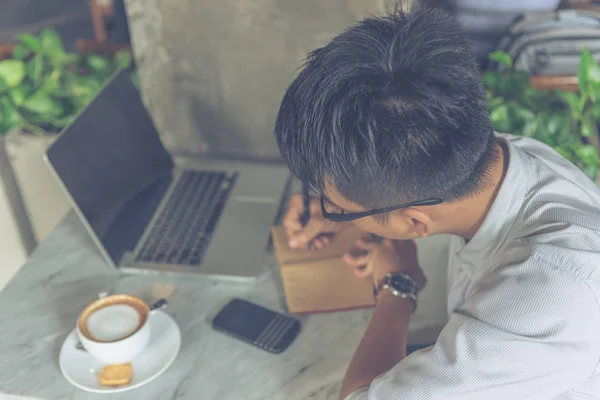 Hombre asiático escribiendo notas en la cafetería — Foto de Stock