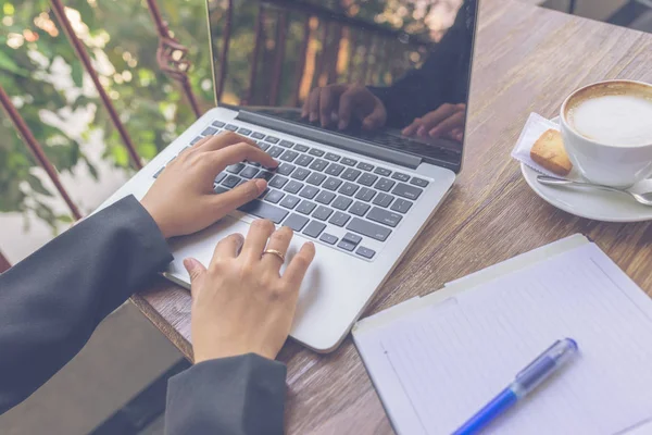 Närbild av kvinna hand bär ring skriva laptop — Stockfoto