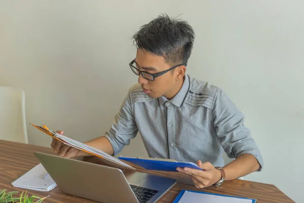 Gerente asiático leyendo informes en la oficina — Foto de Stock
