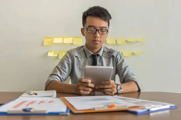 Jovem empresário usando tablet no escritório — Fotografia de Stock