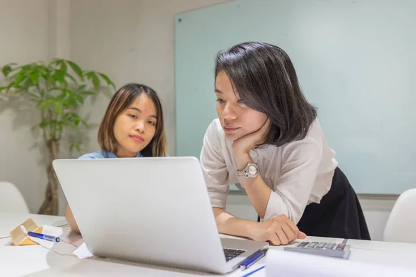 Asian business people working on laptop in office