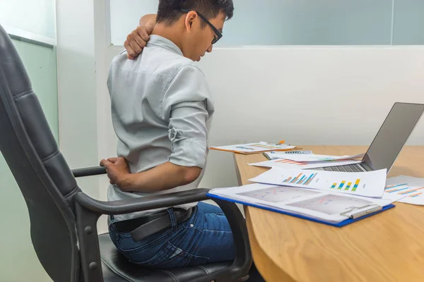 Tired businessman sitting at workplace having neck pain and headache — Stock Photo, Image