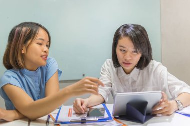 Genç Asyalı çalışanlar raporda ve tablette mali numaradan bahsediyorlar.