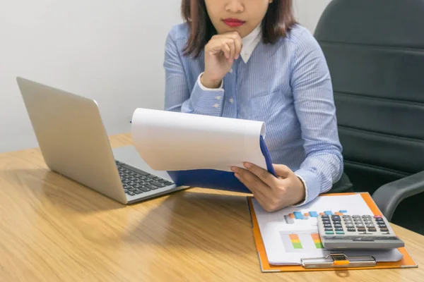 Businesswoman reading financial number on the financial document