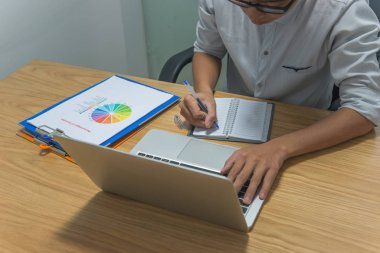 İşadamı notlar yazıyor ve geç saatlere kadar bilgisayar başında çalışıyor.