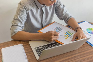 Satış raporunun mali numarasını kontrol eden adam.