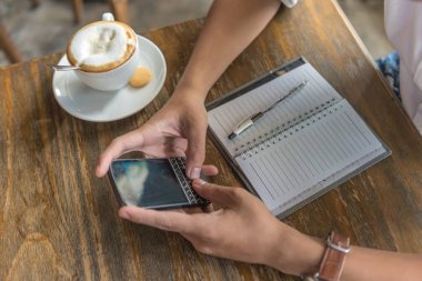 Kahve dükkanında telefon kullanan bir adam.