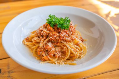 Beyaz tabakta maydanozlu spagetti resmi.