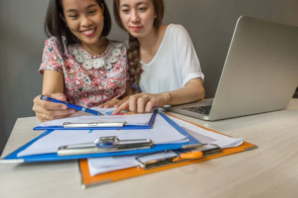 Zwei glückliche junge Mädchen lesen Dokument neben Laptop — Stockfoto