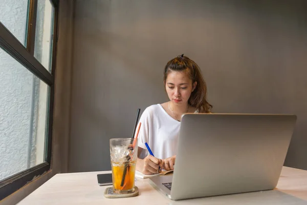 Mujer joven escribiendo notas en la oficina — Foto de Stock