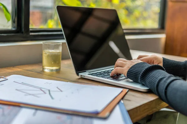 Primer plano de las manos femeninas tecleando teclado portátil junto a la ventana — Foto de Stock