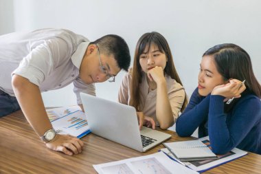Genç iş adamları toplantı odasında takım çalışması yapıyorlar.