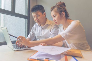 İş adamları ofiste dizüstü bilgisayarla iş konuşuyorlar.