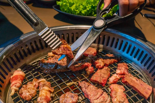 Corte de fatias de carne grelhada no fogão a carvão no restaurante japonês — Fotografia de Stock