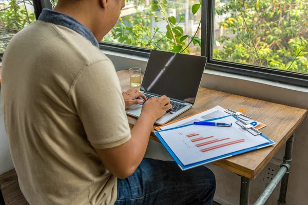 Asiático freelancer trabajando en portátil en rústico espacio de oficina — Foto de Stock
