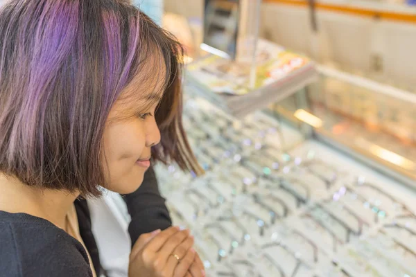 Young girl buy glasses in the optician store