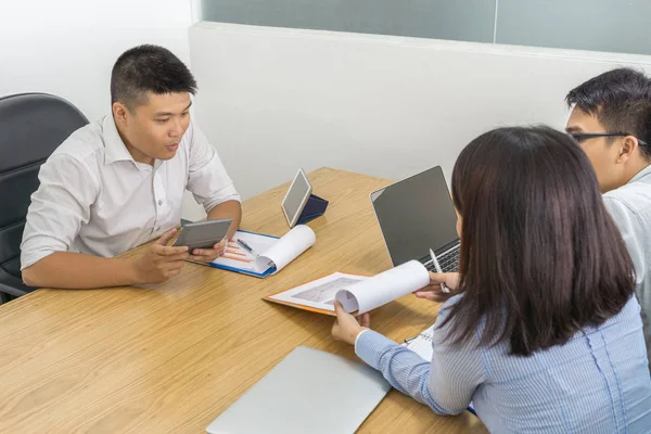 Empresarios asiáticos discutiendo en la sala de reuniones y mostrando estadísticas — Foto de Stock