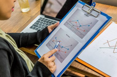 Satış raporunda kalem noktasını kullanarak kadın elinin yakınlaştırılması