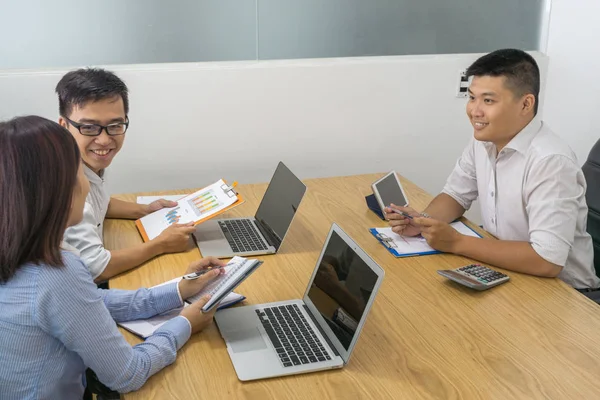 Los empresarios asiáticos discuten sobre el informe en la sala de reuniones — Foto de Stock
