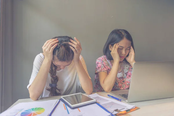 Duas mulheres de escritório sentem dor de cabeça com relatório financeiro — Fotografia de Stock
