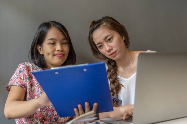 Genç Asyalı kadınlar finans belgelerini tartışıyor 