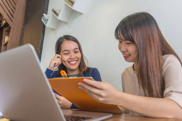 Sonriente oficina damas sentadas con el ordenador portátil y tener una conversación feliz — Foto de Stock