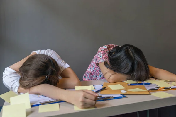 Mulheres exaustas dormindo na mesa cheia de documento — Fotografia de Stock