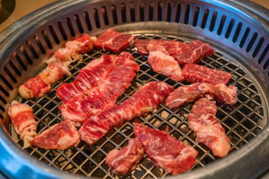 Kömür ocağında çiğ et dilimi Japon usulü barbekü yakiniku. 