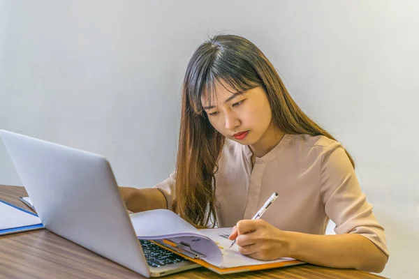 Asiática joven oficina dama trabajando en portátil y documentos — Foto de Stock