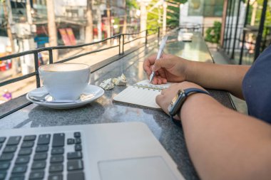 Kafeteryada notlar yazan genç bir kadın.