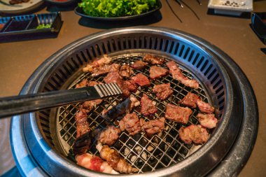 Japon barbekü restoranında kömür ocağında ızgara et dilimleri.