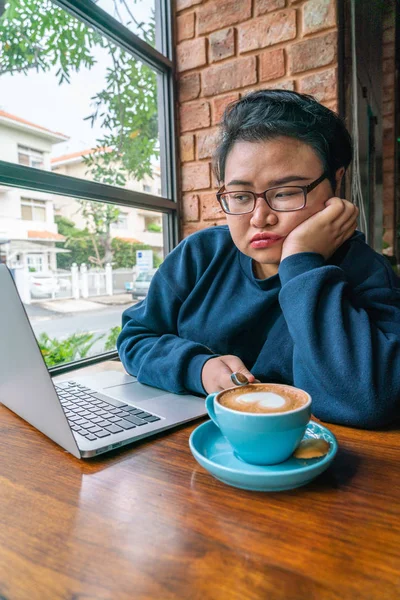 Perezoso y aburrido mujer asiática que trabaja en el ordenador portátil — Foto de Stock