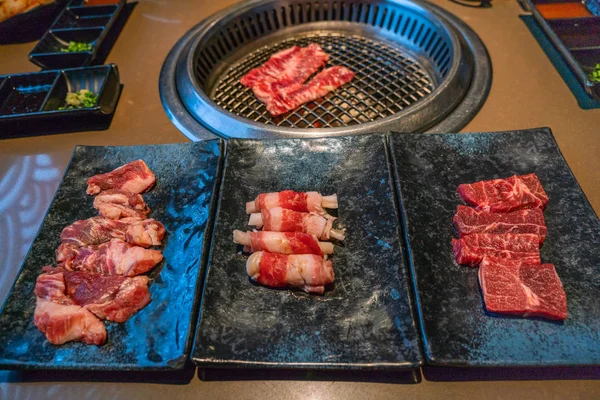 Carne cruda y rebanadas de cerdo a la parrilla como barbacoa de estilo japonés — Foto de Stock