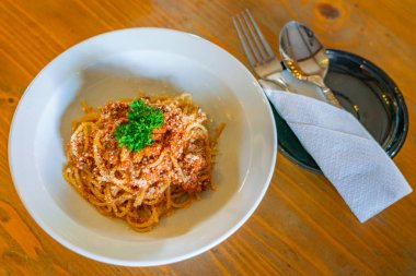 Peynir ve maydanozla süslenmiş lezzetli bir spagetti tabağı. 