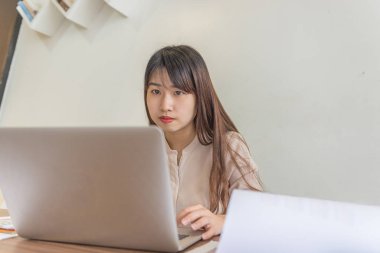 Ofisteki kadın iş yerinde dizüstü bilgisayarla çalışıyor.