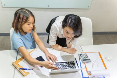 Ofis çalışanları finansal verileri bilgisayarda tartışıyor