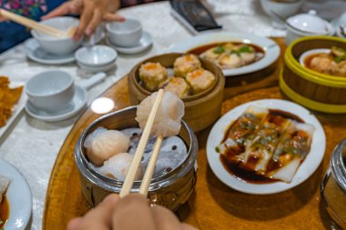 İnsanlar yemek çubukları kullanıyor ve restoranda Hong Kong 'lu gamsum yiyorlar.