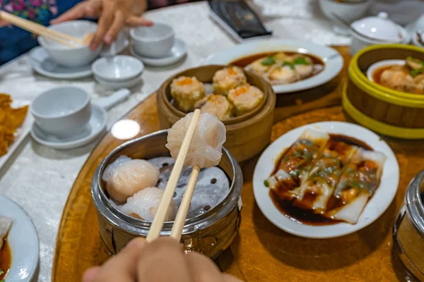 Persone che usano bacchette e hanno Hong Kong dimsum nel ristorante — Foto Stock