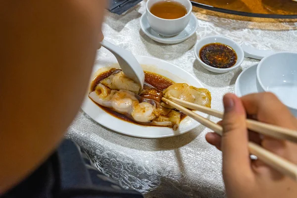 Umano usando bacchette mentre mangia rotoli di riso al vapore cinesi — Foto Stock