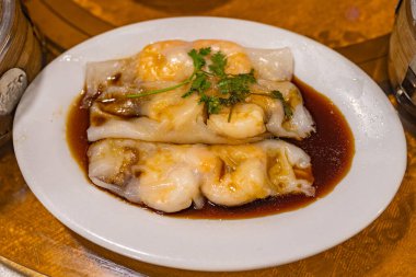 Chinese steamed shrimp rice rolls served with soy sauce clipart