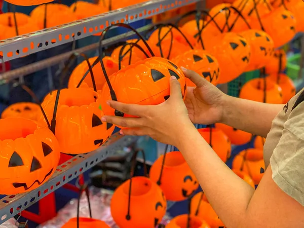 Woman choosing pumpkin jack o lantern at Halloween accessories shop — ストック写真