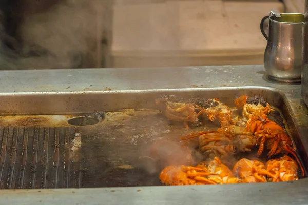 Aragoste alla griglia su fornelli elettrici con fumo all'interno di ristoranti cucina — Foto Stock