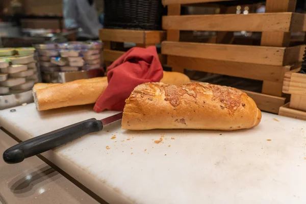 Demi-pain de pain baguette frais sur la planche à découper — Photo