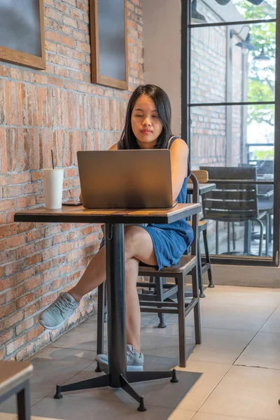 Азиатский фрилансер работает на ноутбуке в деревенской кофейне — стоковое фото