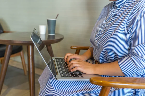 Γυναίκα κάθεται σε ξύλινη πολυθρόνα και τη χρήση laptop — Φωτογραφία Αρχείου