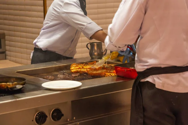 İki restoran şefi mutfakta ızgara peynirli ıstakoz hazırlıyor. — Stok fotoğraf