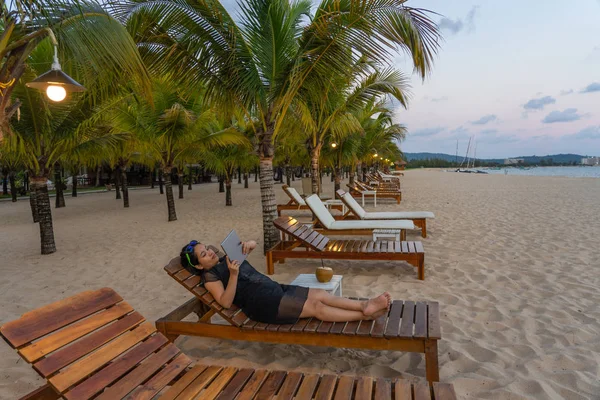 Asian tourist use tablet to surf the Internet