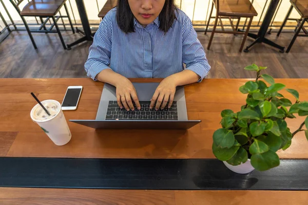 Chica estudiante casual usando el ordenador portátil al lado del teléfono celular y beber — Foto de Stock