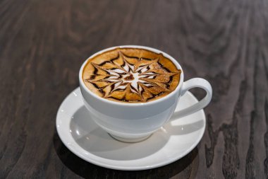 Masanın üzerinde bir fincan sıcak mocha sanat latte kahvesi.