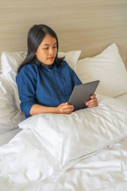 Tablette internette sörf yapan Asyalı kadın.